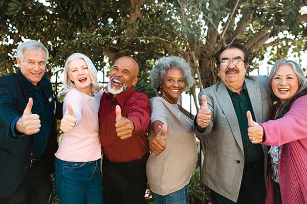 Cheerful multi-ethnic senior friends showing thumbs up. Portrait of smiling retired men and women. They are in casuals.