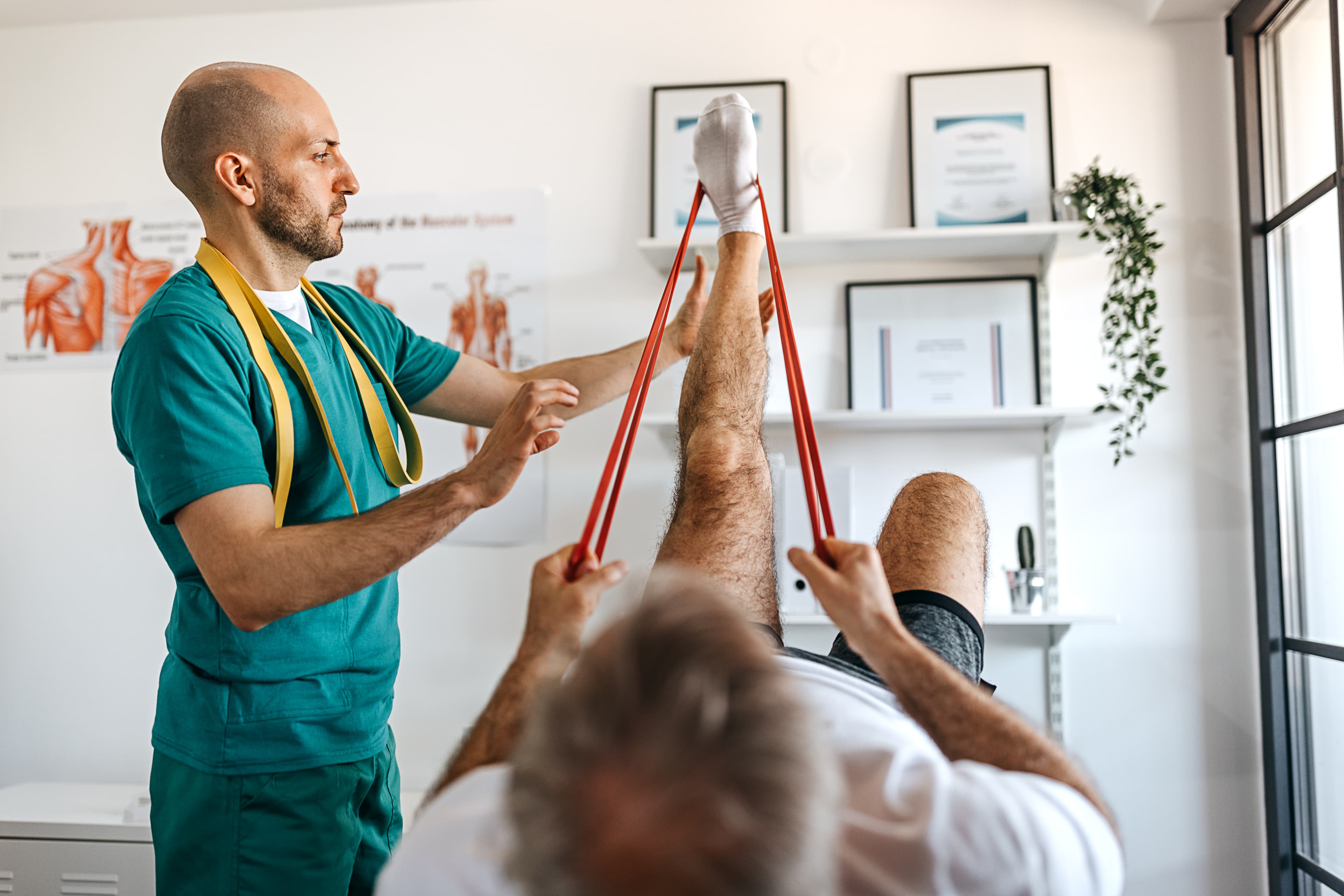 Photo of senior man has physical leg therapy with his doctor